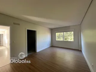 Vista interna de um ambiente com piso de madeira e paredes brancas.