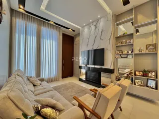 Sala de estar moderna com sofá e televisão em um ambiente claro.