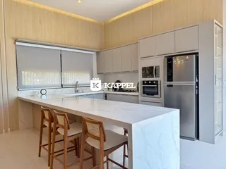 Cozinha moderna com ilha de mármore e armários em madeira.