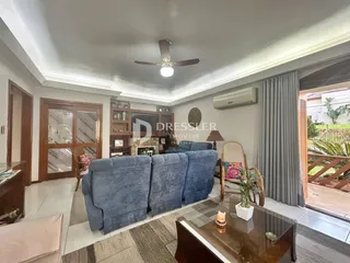 Sala de estar com sofá azul e portas de madeira na residência.