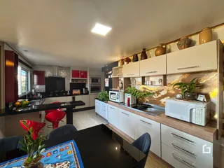 Vista da cozinha e sala de jantar de uma residência.