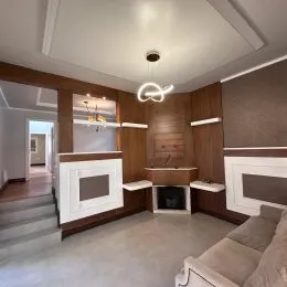 Hall de entrada com escadaria e lareira em ambiente residencial.