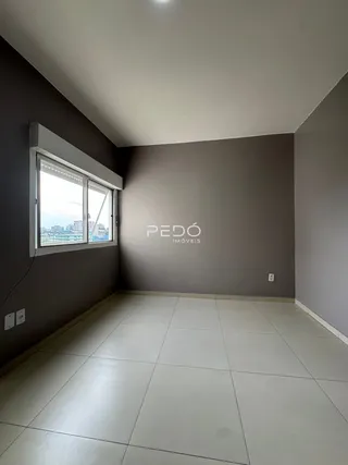 Vista interna de um cômodo com piso claro e parede cinza.