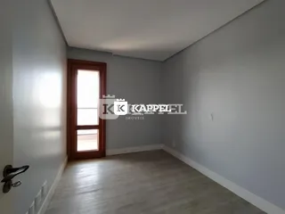 Hall de entrada com piso de madeira clara e parede cinza na residência.