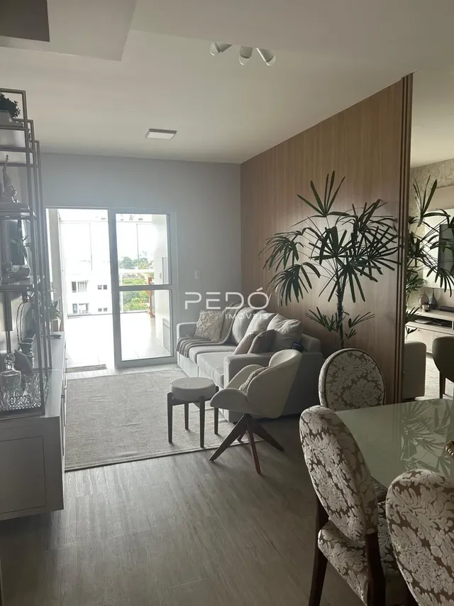 Sala de estar com sofá e piso de madeira em um imóvel no Brasil.