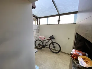 Foto de um interior com um piso de cerâmica e uma bicicleta encostada na parede.