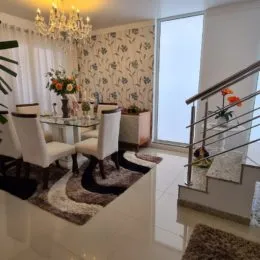 Sala de estar com mesa de centro e cadeiras decoradas.