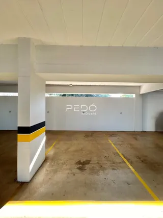 Interior de um espaço com piso de concreto e paredes brancas em uma propriedade.