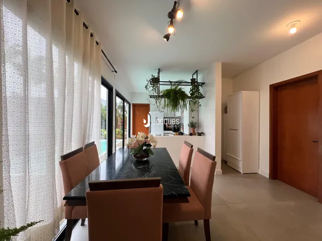Vista de uma sala de jantar com mesa escura e cadeiras em um imóvel em Lajeado.