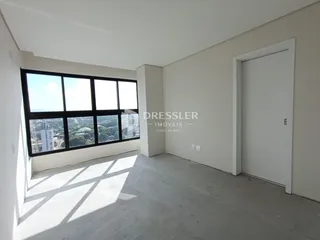 Uma sala com grande janela e vista para a paisagem.