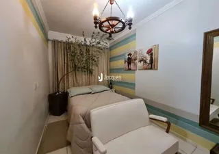Quarto com cama e cortinas em ambiente interno.