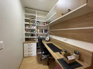 Foto de um escritório com estantes de madeira e mesa de trabalho.