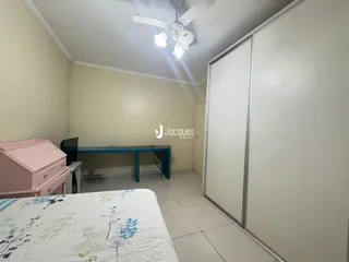 Quarto com armário e cama em ambiente interno.