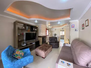 Sala de estar com teto arqueado e lareira em imóvel em Lajeado.