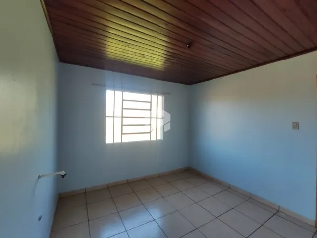 Imagem de um cômodo interno com piso de cerâmica e teto de madeira.