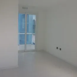 Hall de corredor com paredes brancas e portas de vidro.