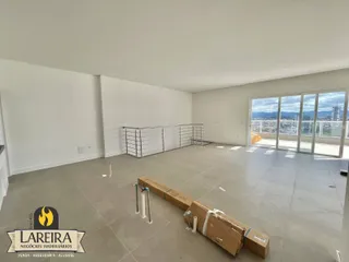 Ambiente interno de uma sala ampla com vista para a paisagem urbana.