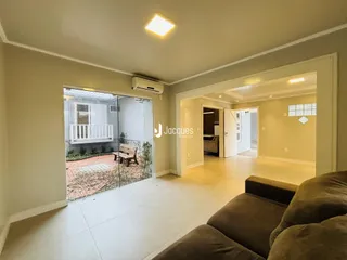 Sala de estar com porta de vidro abrindo para um pátio externo.