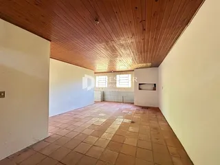 Imagem de um ambiente interno com piso de tijolos e teto de madeira.