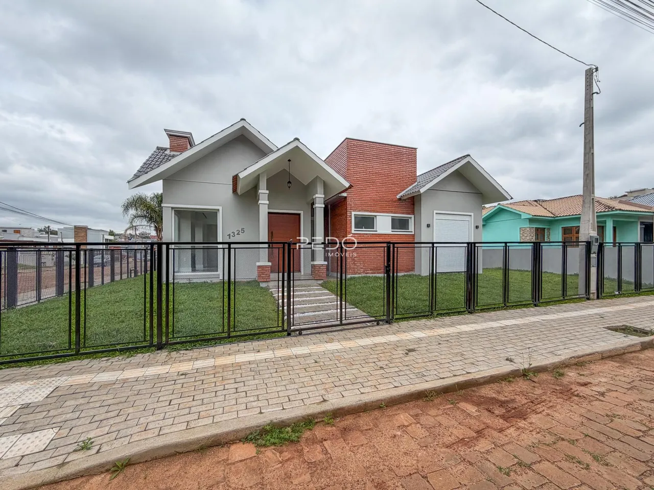 Fachada de uma casa em Lajeado, Brasil, com cerca e jardim.