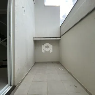 Corredor interno com piso de cerâmica e paredes brancas.