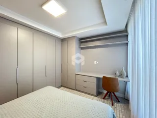 Quarto com armários embutidos e cabeceira.