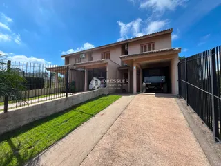Fachada de uma residência em Lajeado, Brasil, com muro e jardim.