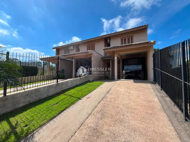 Fachada de uma residência em Lajeado, Brasil, com muro e jardim.