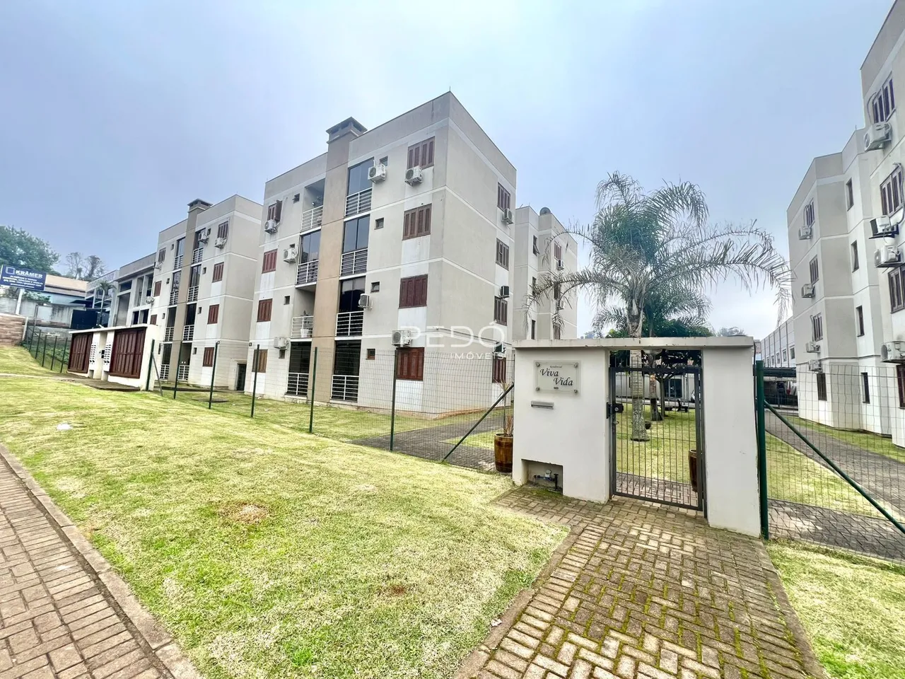 Vista da fachada de um conjunto de apartamentos em Lajeado, Brasil, com jardim frontal.