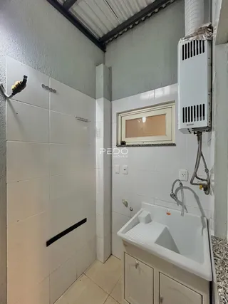 Foto de um banheiro com revestimento cerâmico branco.