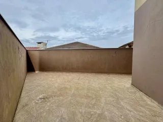 Vista de um pátio externo pavimentado com paredes laterais.