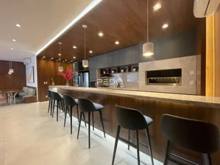 Vista da cozinha moderna com bancada e banquetas em Lajeado, Brasil.