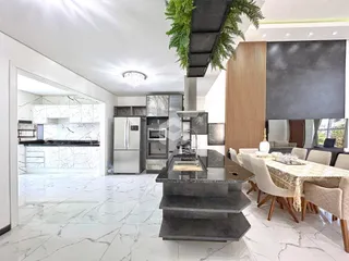 Uma sala de estar e cozinha moderna com piso de mármore branco.