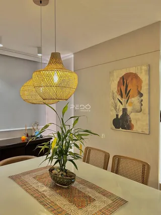 Uma mesa de jantar com luminárias pendentes em um ambiente claro.