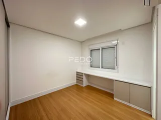 Foto de uma sala com piso de madeira clara e paredes brancas.