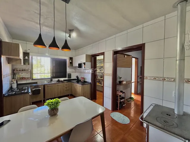Foto interna de uma cozinha com armários de madeira e piso de cerâmica.