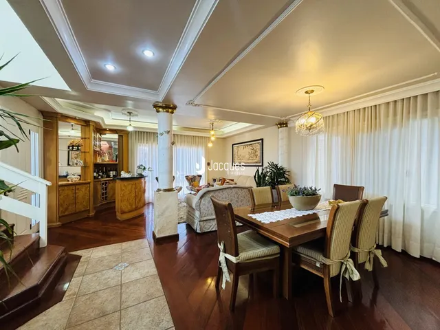 Ambiente interno de sala de jantar com piso de madeira e molduras de teto.