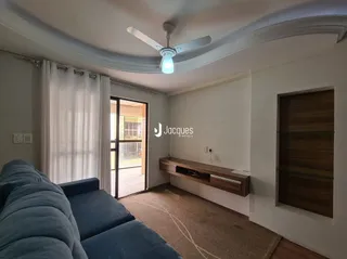 Sala de estar com sofá azul e janela iluminada.