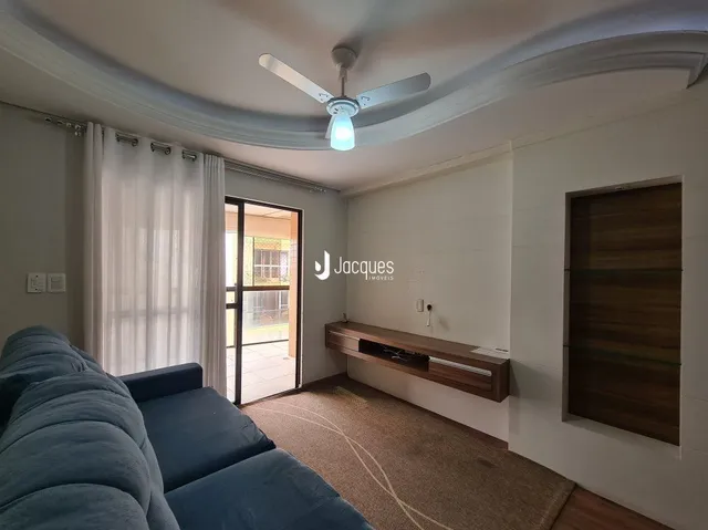 Sala de estar com sofá azul e janela iluminada.