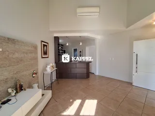 Sala de estar com piso de cerâmica e parede de destaque na residência.