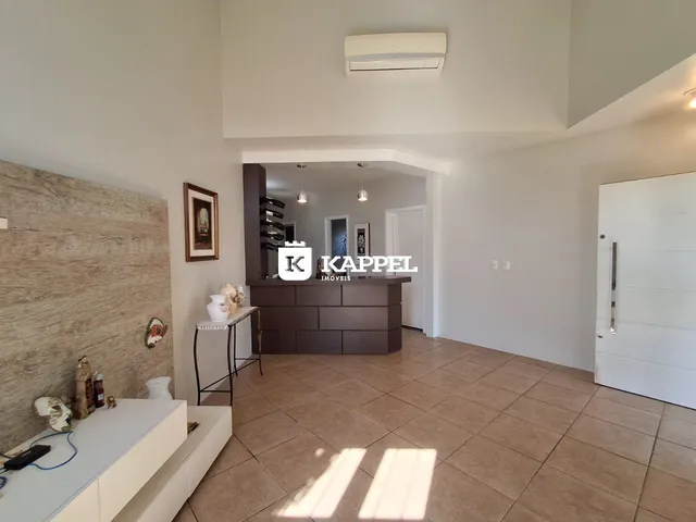 Sala de estar com piso de cerâmica e parede de destaque na residência.