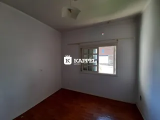 Ambiente interno com piso de madeira e janela em um imóvel.