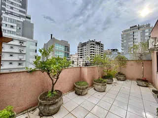Vista de uma área externa pavimentada com vasos de plantas em Lajeado, Brasil.