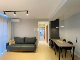 Sala de estar com sofá e mesa de jantar em um apartamento.
