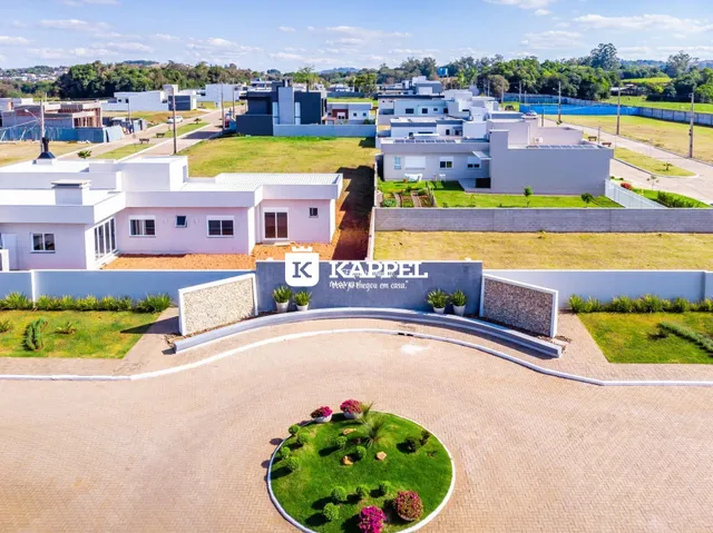Fachada de uma casa moderna branca em Lajeado, Brasil, com jardim bem cuidado.
