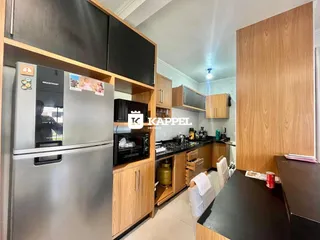 A cozinha apresenta armários modernos e eletrodomésticos em aço inoxidável.