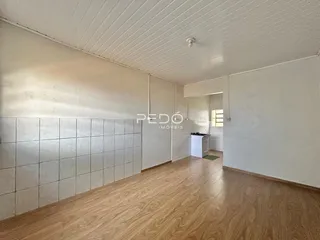 Interior de uma sala com piso de madeira e revestimento de cerâmica.