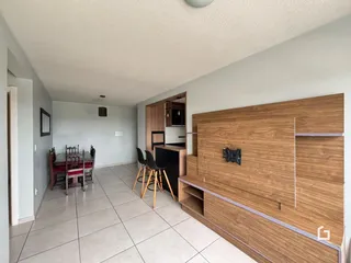 Interior de uma sala de jantar e cozinha com armários de madeira em Lajeado.