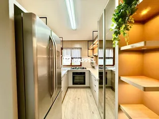 Foto de uma cozinha moderna com armários brancos e piso de madeira clara.