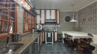 Foto de uma cozinha com armários de madeira e piso de cerâmica.